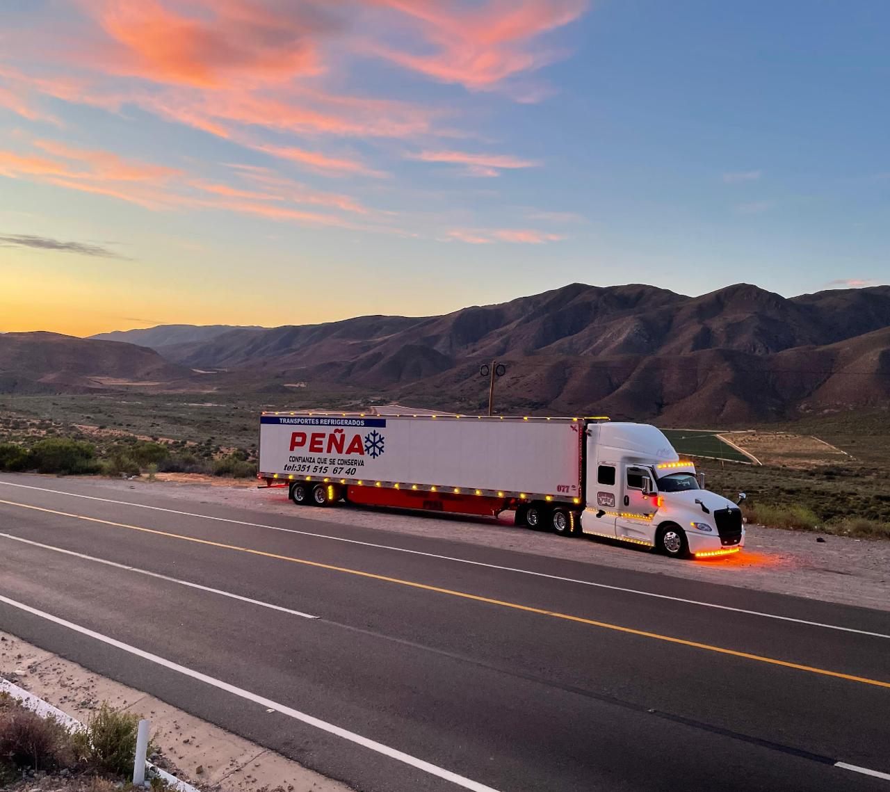 Unidad refrigerada de Transportes Peña en carretera al atardecer